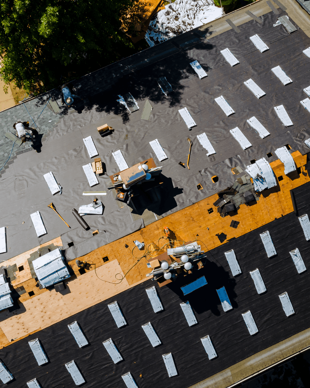 Aerial view of a shingle roof replacement in progress, with old shingles removed down to the deck